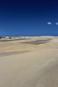 Scenic view of desert against blue sky