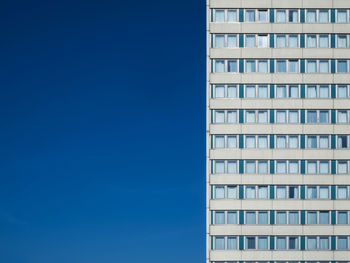 Low angle view of modern building against clear blue sky