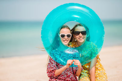 Portrait of sisters sitting on beach