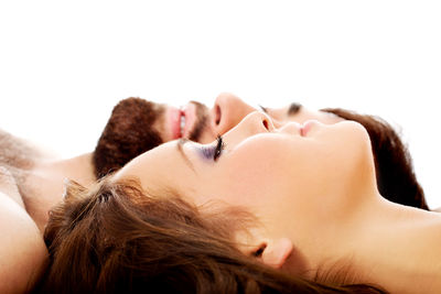 Portrait of woman lying down against white background