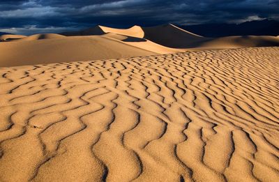 Sand dunes in desert against sky