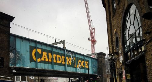 Low angle view of text on building against sky