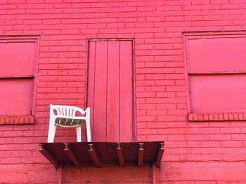 Chairs on pink brick wall