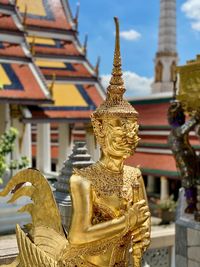 Golden winged statue against temple building