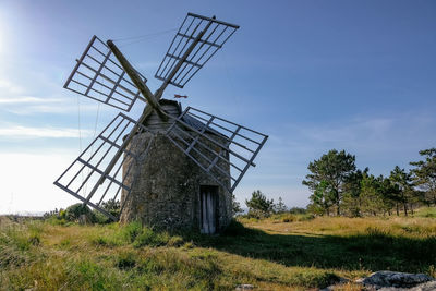 Traditional windmill on field against sky