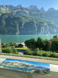 Scenic view of lake by mountains against sky