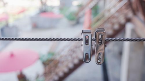 Close-up of clothespins hanging on wire metal