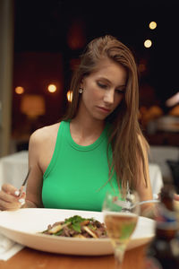 Young woman having food at restaurant