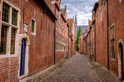 Alley amidst buildings in city against sky