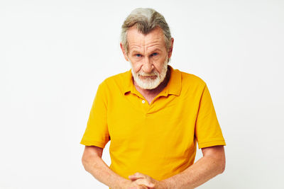 Portrait of senior man standing against white background