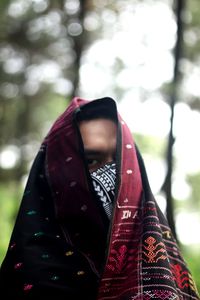 Close-up of woman with umbrella against blurred background