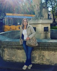 Portrait of smiling woman standing against building