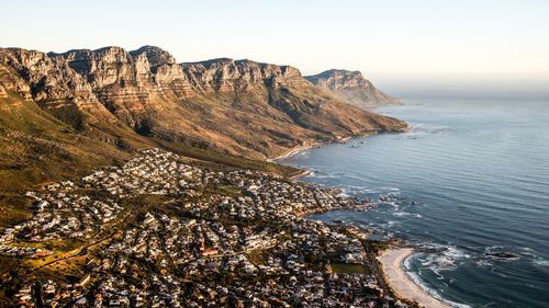 Scenic view of sea and mountains against clear sky