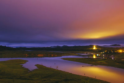 Scenic view of river against sky at sunset