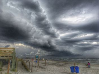 Scenic view of beach against cloudy sky