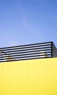 Low angle view of yellow wall against clear sky