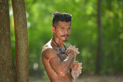 Portrait of young man holding plant