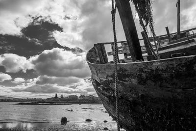 Boat in sea against cloudy sky