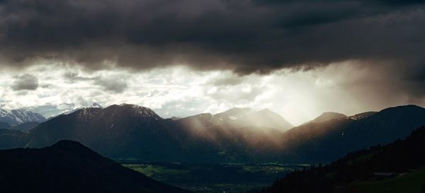 Scenic view of mountains against storm clouds