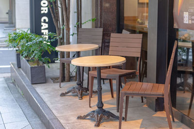 Empty chairs and tables at sidewalk cafe