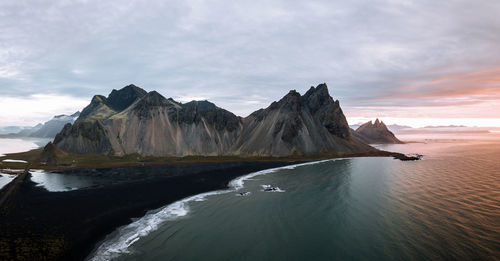 Scenic view of sea mountains against sky during sunset