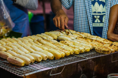 Midsection of man preparing food at market stall