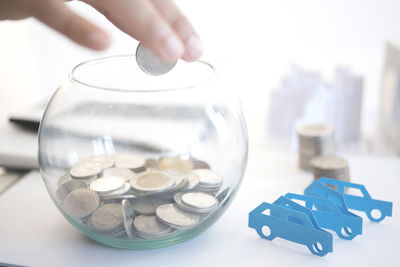 Close-up of hands and coins on table