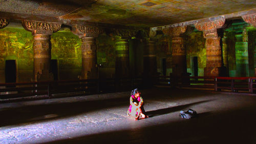 Woman with umbrella in corridor of building