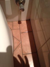 Low section of man on tiled floor at home