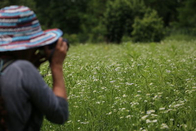 Woman photographing on grassy field