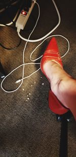 Low section of person wearing canvas shoes on floor