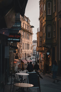 People on street amidst buildings in city