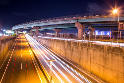 Light trails on bridge in city at night