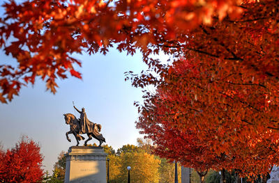 Low angle view of statue against sky during autumn