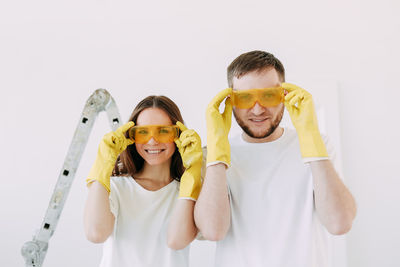 Happy smiling married couple engaged in renovation repair in the room of the house preparing to move