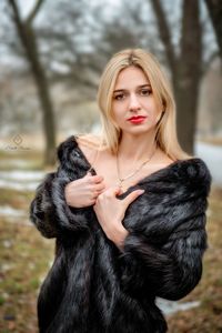 Portrait of young woman with dog against trees