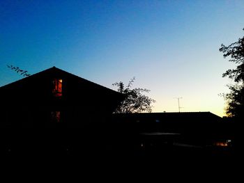 Silhouette houses against clear sky