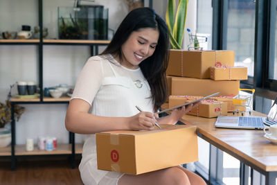 Smiling young woman holding camera in box