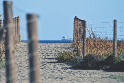 Fence on beach against clear sky