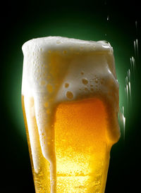 Close-up of beer glass against black background