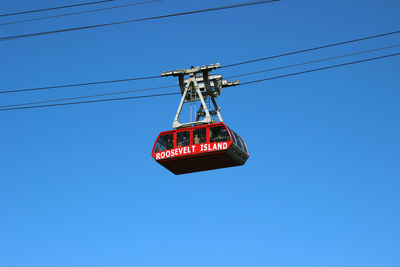 Low angle view of overhead cable car against blue sky