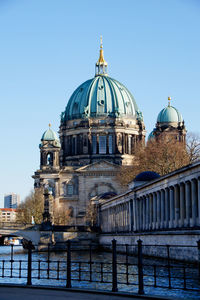 Berlin cathedral by spree river against blue sky