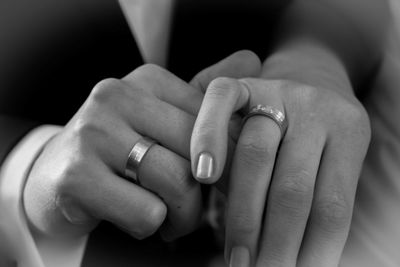 Cropped image of couple wearing finger rings and holding hands