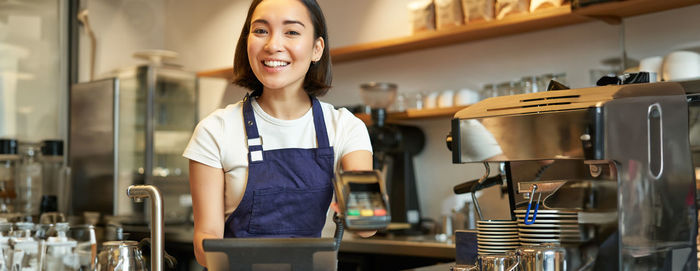 Portrait of young woman standing in cafe