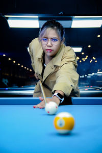 Portrait of woman playing pool
