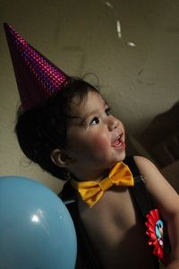Smiling baby boy wearing party hat during his first birthday party at home