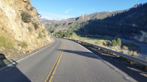 Country road amidst mountains against sky