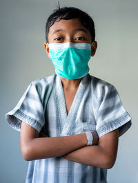 Portrait of boy standing against white background