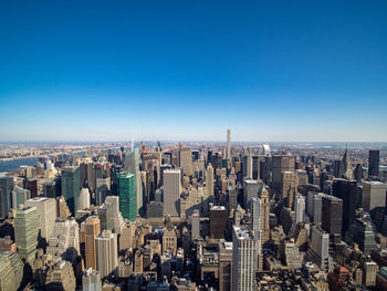 High angle view of modern buildings against blue sky