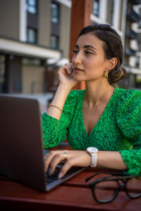 Young woman using laptop at table